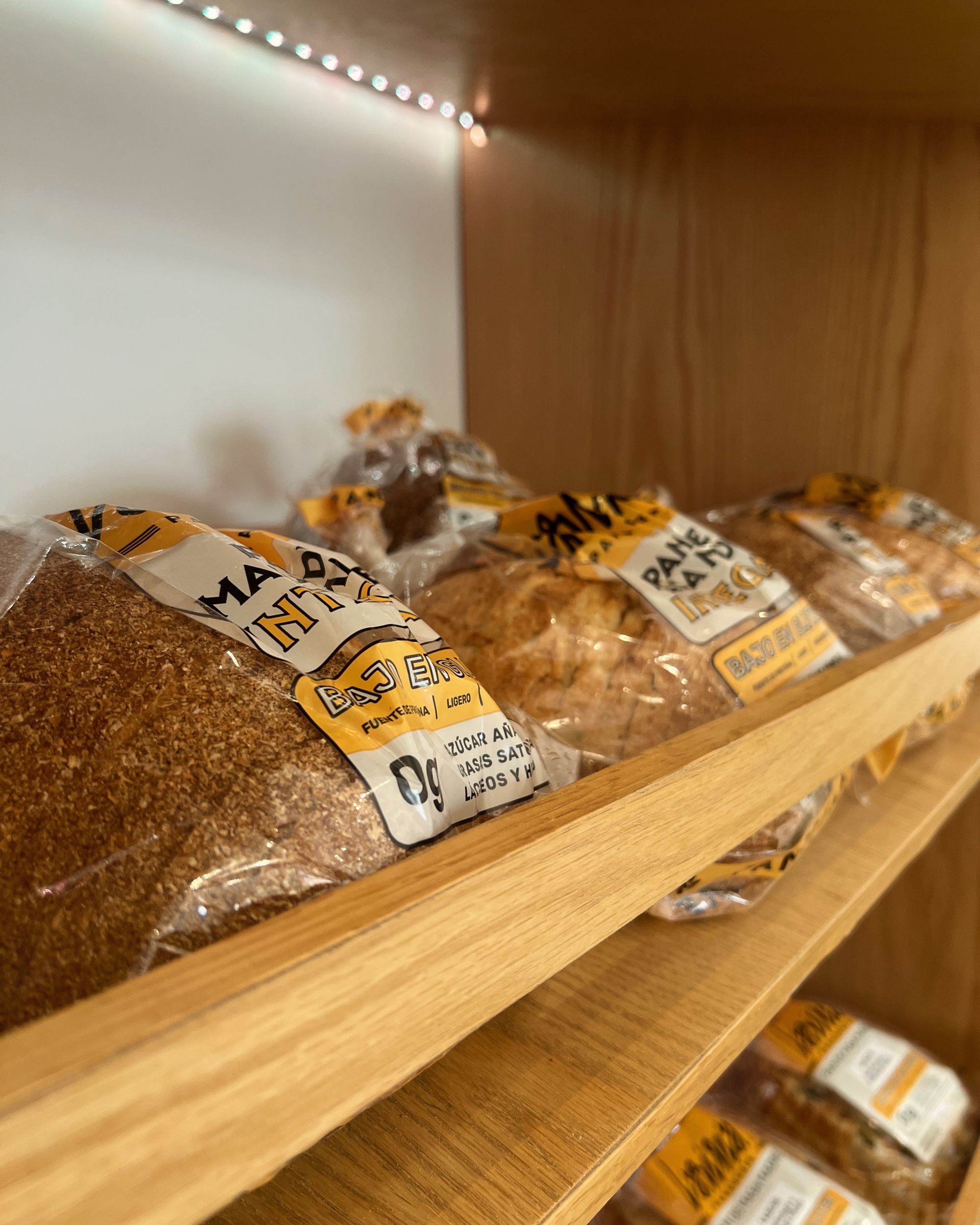 Repisas de madera con pan de masa madre empacado en la panadería